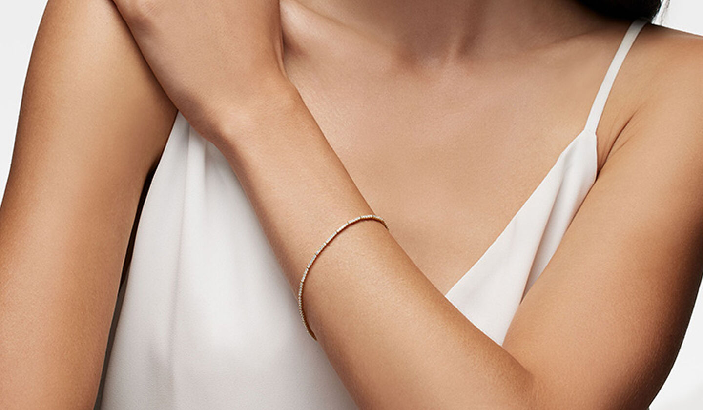 A woman wearing a Birks Ros&eacute;e du Matin diamond and yellow gold bracelet.